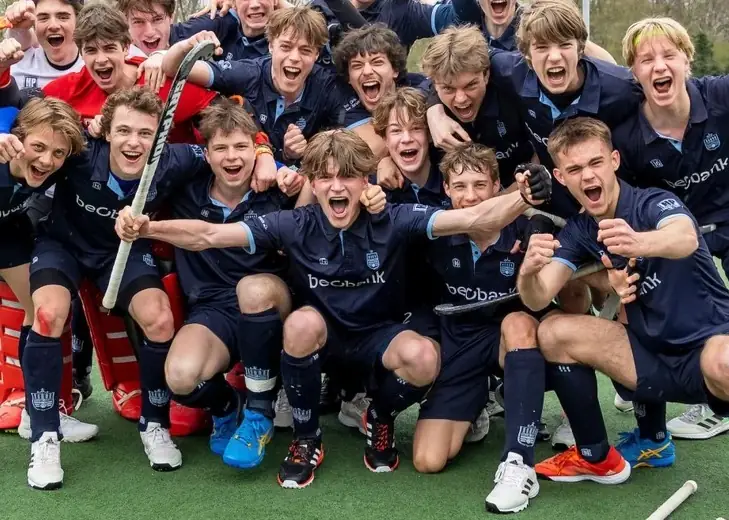 Club hockey team celebrating on the pitch