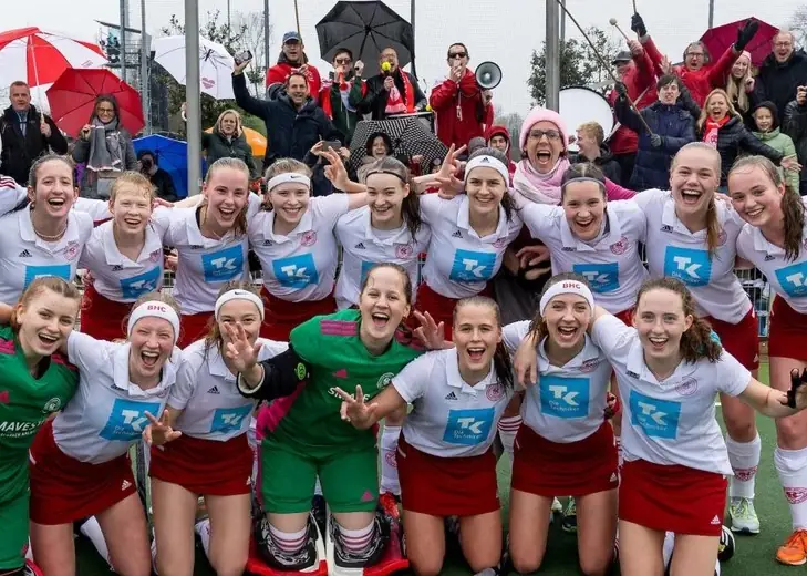 Club hockey team celebrating with their supporters